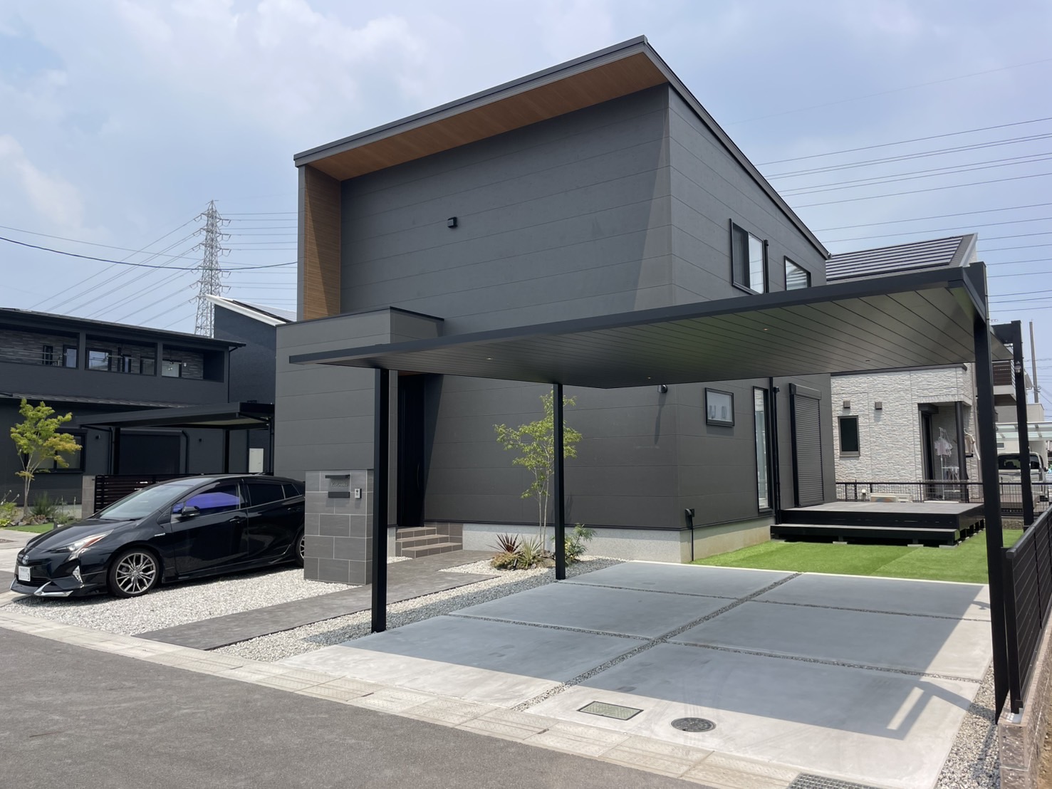 リノベーションが完成した住まいで、施主夫婦と職人が木のダイニングテーブルを囲み仕上がりを確認している自然な引き渡し風景